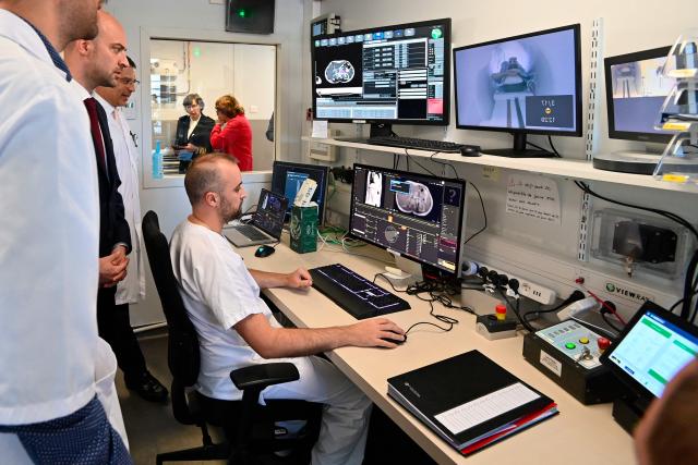 France's Foreign Affairs Minister Jean-Noel Barrot (L) looks at researchers working at the radiotherapy control room during a visit of the Montpellier Cancer Institute, in Montpellier, southern France, on April 17, 2026. (Photo by Sylvain THOMAS / AFP)
