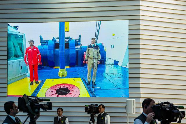 Members of the media work in front of a huge screen broadcasting a ceremony launching the fourth of seven planned development phases at Galkynysh gas field, the world's second-largest gas field in the Karakum desert about 400 kilometres (250 miles) east of the capital Ashgabat, on April 17, 2026. Turkmenistan and China broke ground on April 17, 2026 on works to expand production at the giant Galkynysh gas field, strengthening Beijing's already dominant position in the secretive Central Asian nation's energy sector. (Photo by AFP)