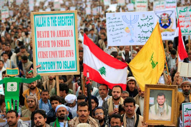 Supporters of the Iran-backed Houthi movement hold up the Lebanese flag (C) and the Lebanese Hezbollah party flag (R), as they rally in solidarity with Iran and Lebanon in the Yemeni capital Sanaa on April 17, 2026. The Middle East war has created an "unprecedented shock" for the region's economies with no guarantee of a quick recovery, a senior International Monetary Fund official has told AFP. Five of the Gulf's eight oil- and gas-producing countries face a contraction this year, the IMF said in a regional report published on April 16. (Photo by Mohammed HUWAIS / AFP)