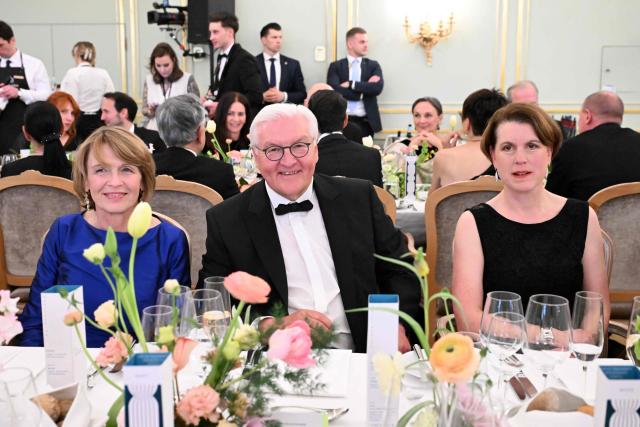 Germany's President Frank-Walter Steinmeier (C) and his wife Elke Budenbender (L) are pictured with Melissa Eddy (R), correspondent for 'The New York Times' and Chair of the Association of the Foreign Press in Germany, at the dinner table during the Bundespresseball (German Federal Press Ball) in Berlin, Germany, on April 18, 2026. (Photo by Annette Riedl / POOL / AFP)