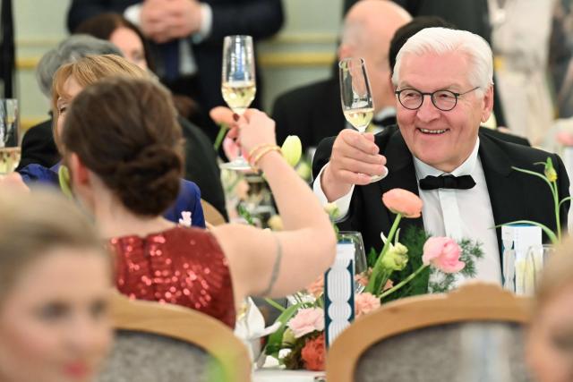 Germany's President Frank-Walter Steinmeier stösst beim Dinner des Bundespresseballs mit Regina Kramer, Ehefau des Vorsitzender der Bundespressekonferenz, at the dinner table during the Bundespresseball (German Federal Press Ball) in Berlin, Germany, on April 18, 2026. (Photo by Annette Riedl / dpa pool / AFP)