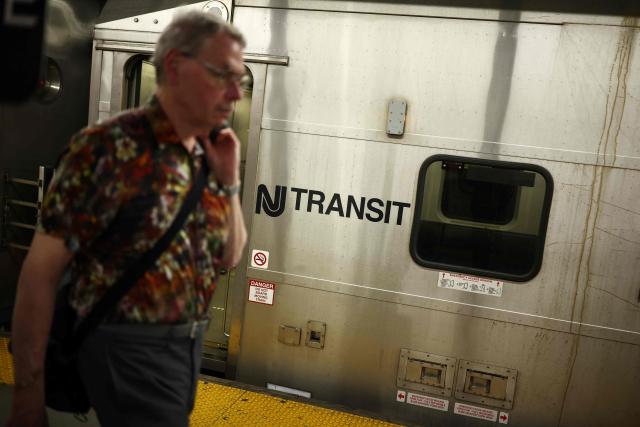 A person walks on the platform next to a NJ Transit train at New York Penn Station in New York City on April 17, 2026. Football fans have expressed outrage at the exorbitant price of transit fares to get to World Cup matches, following reports that US transport authorities have jacked up prices just for this summer's tournament. New Jersey Transit is planning to charge fans more than $100 for tickets from Penn Station in Manhattan to MetLife Stadium in New Jersey during the World Cup, according to a report in The Athletic. A return ticket for the journey normally costs $12.90. (Photo by CHARLY TRIBALLEAU / AFP)