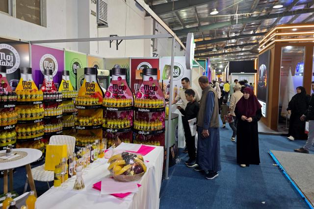 Visitors pause at a stand during the 52nd Tripoli International Fair, which features some 285 local and foreign companies and is drawing large crowds in the Libyan capital, Tripoli on April 17, 2026. (Photo by Mahmud Turkia / AFP)
