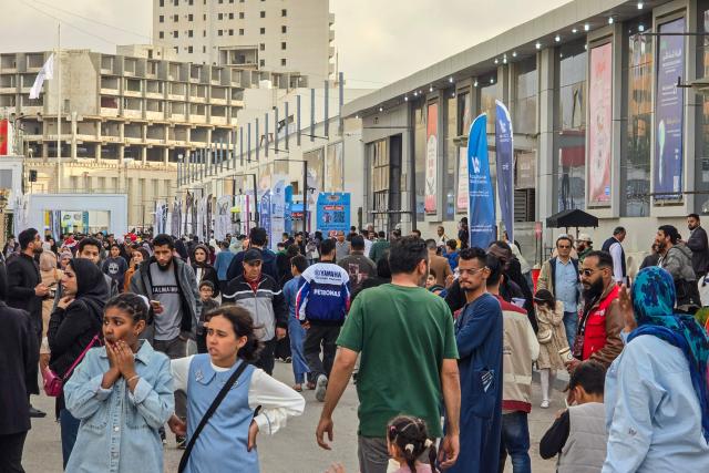 Visitors stroll through the grounds of the 52nd Tripoli International Fair, which features some 285 local and foreign companies and is drawing large crowds in the Libyan capital, Tripoli on April 17, 2026. (Photo by Mahmud Turkia / AFP)