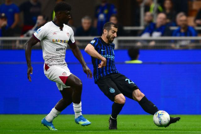 Inter Milan’s Armenian midfielder #22 Henrikh Mkhitaryan fights for the ball with Cagliari’s French midfielder #8 Michel Adopo during the Italian Serie A football match between Inter Milan and Cagliari at San Siro stadium in Milan, on April 17, 2026. (Photo by MARCO BERTORELLO / AFP)