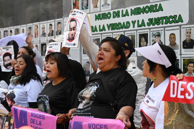 Members of the collective for the search of missing persons, “Una Luz en el Camino,” shout slogans during a press conference at the so?called Wall of Memory for Truth and Justice, located at the headquarters of the Comprehensive Care Center for the Search for Persons in Mexico City, on April 17, 2026. Several groups searching for missing persons announced on April 17 the discovery of more than 1,000 bone fragments in a lakeside area of Mexico City, where Mexican authorities have been carrying out excavations for more than a week. (Photo by Yuri CORTEZ / AFP)