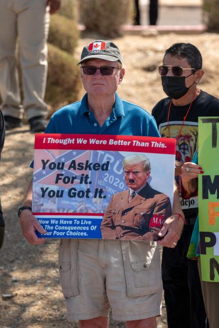 A person holds a sign depicting US President Donald Trump as Hitler as they protest his visit to Arizona outside Dream City Church, where the Turning Point USA "Build the Red Wall" event is being held, in Phoenix, Arizona, on April 17, 2026. President Trump is in Arizona to speak at the Turning Point USA event, the conservative political organization founded by late activist Charlie Kirk. (Photo by Olivier Touron / AFP)