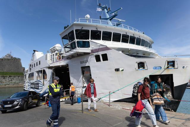 Cars and pedestrians disembark a ferry in Belle-Ile-en-Mer, western France, on April 17, 2026. (Photo by Fred TANNEAU / AFP)