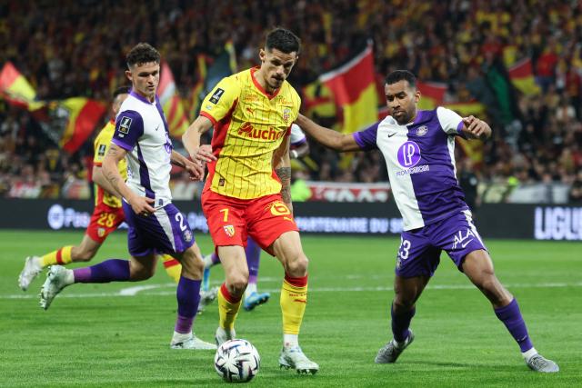 Toulouse's Venezuelan midfielder #23 Cristian Casseres Jr. (R) fights for the ball with Lens' French forward #07 Florian Sotoca during the French L1 football match between RC Lens and Toulouse FC at the Stade Bollaert-Delelis in Lens, northern France, on April 17, 2026. (Photo by Francois LO PRESTI / AFP)