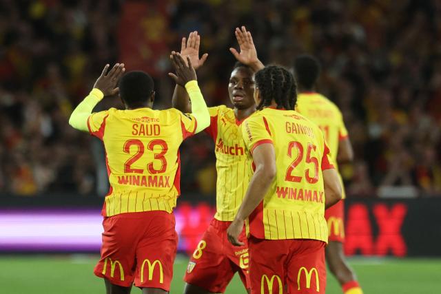 Lens' Saudi Arabian defender #23 Saud Abdulhamid (L) celebrates with Lens' Malian midfielder #08 Mamadou Sangare and teammates after scoring his team first goal during the French L1 football match between RC Lens and Toulouse FC at the Stade Bollaert-Delelis in Lens, northern France, on April 17, 2026. (Photo by Francois LO PRESTI / AFP)
