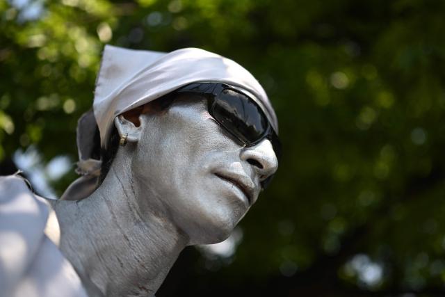 Street performer Samuel Gutierrez, 37, looks on as he waits in the street to juggle sharp metal blades amid midday traffic in San Salvador on April 17, 2026. Samuel says that after ten years in the trade, he has performed on the main streets and avenues of San Salvador, earning between $5 and $10 a day, an income he supplements by selling bracelets and handicrafts he makes himself to cover his family’s expenses. (Photo by Marvin RECINOS / AFP)