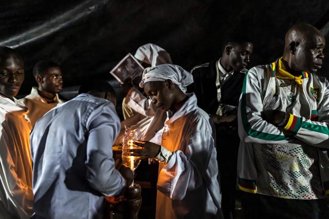 People light candles during a night vigil prayer on the fifth day of Pope Leo XIV’s 11-day apostolic journey to Africa in Yaounde, Cameroon, on April 17, 2026. (Photo by PATRICK MEINHARDT / AFP)