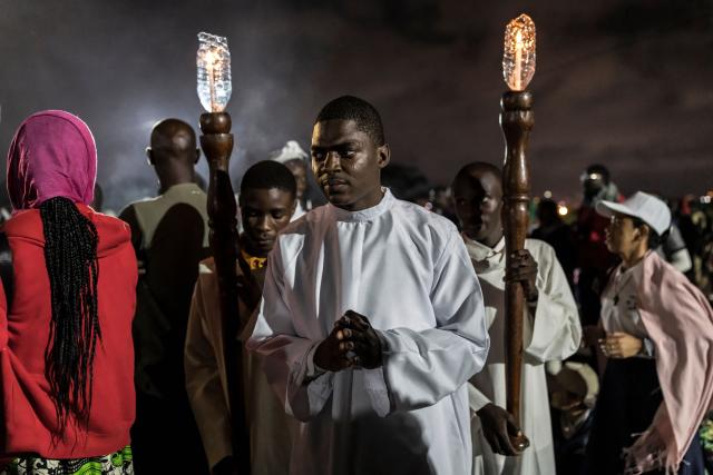 Faithful lead a procession during a night vigil prayer on the fifth day of Pope Leo XIV’s 11-day apostolic journey to Africa in Yaounde, Cameroon, on April 17, 2026. (Photo by PATRICK MEINHARDT / AFP)