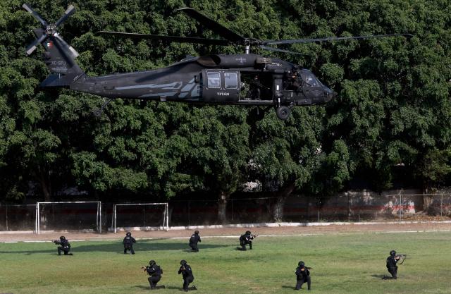 Jalisco state police officers descend from a Black Hawk helicopter during a demonstration and closing ceremony of the Urban Tactical Operations Course in Tlaquepaque, Jalisco, Mexico on April 17, 2026. The Urban Tactical Operations Course in conjunction with Colombian Police was part of the 2026 FIFA World Cup security preparations. (Photo by ULISES RUIZ / AFP)