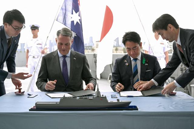 Australia's Deputy Prime Minister and Minister for Defence Richard Marles (2nd L) and Japan's Minister of Defense Koizumi Shinjiro (2nd R) sign the contract for Japan to deliver the first three of Mogami-class warships, in Melbourne on April 18, 2026. Japan agreed on April 18 on a deal to provide Australia's navy with the first of almost a dozen stealth frigates, part of a wider military build up by Canberra aimed at boosting its long-range firepower to deter China. (Photo by William WEST / AFP)