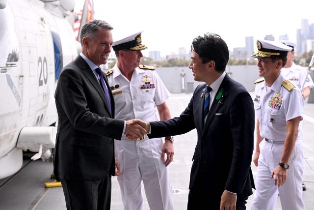 Australia's Deputy Prime Minister and Minister for Defence Richard Marles (L) shakes hands with Japan's Minister of Defense Koizumi Shinjiro (2nd R) after the signing of the contract for Japan to deliver the first three of Mogami-class warships, in Melbourne on April 18, 2026. Japan agreed on April 18 on a deal to provide Australia's navy with the first of almost a dozen stealth frigates, part of a wider military build up by Canberra aimed at boosting its long-range firepower to deter China. (Photo by William WEST / AFP)