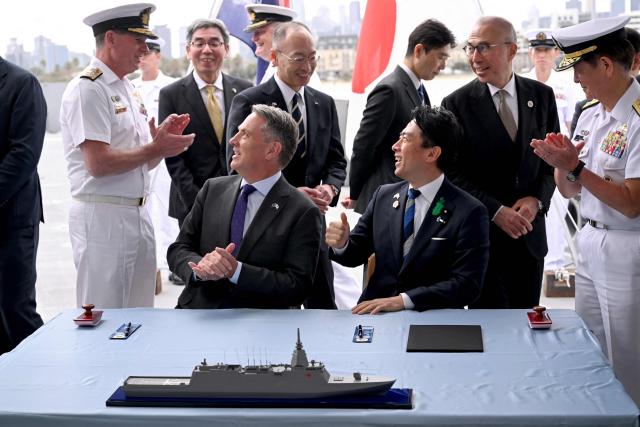 Australia's Deputy Prime Minister and Minister for Defence Richard Marles (2nd L) and Japan's Minister of Defense Koizumi Shinjiro (3rd R) applaud after the signing of the contract for Japan to deliver the first three of Mogami-class warships, in Melbourne on April 18, 2026. Japan agreed on April 18 on a deal to provide Australia's navy with the first of almost a dozen stealth frigates, part of a wider military build up by Canberra aimed at boosting its long-range firepower to deter China. (Photo by William WEST / AFP)