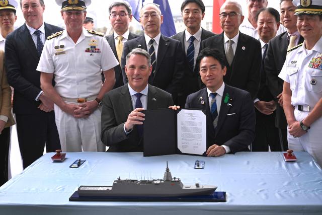 Australia's Deputy Prime Minister and Minister for Defence Richard Marles (front L) and Japan's Minister of Defense Koizumi Shinjiro (front R) pose for a photo after the signing of the contract for Japan to deliver the first three of Mogami-class warships, in Melbourne on April 18, 2026. Japan agreed on April 18 on a deal to provide Australia's navy with the first of almost a dozen stealth frigates, part of a wider military build up by Canberra aimed at boosting its long-range firepower to deter China. (Photo by William WEST / AFP)