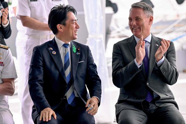 Australia's Deputy Prime Minister and Minister for Defence Richard Marles (R) and Japan's Minister of Defense Koizumi Shinjiro chat before the signing of the contract for Japan to deliver the first three of Mogami-class warships, in Melbourne on April 18, 2026. Japan agreed on April 18 on a deal to provide Australia's navy with the first of almost a dozen stealth frigates, part of a wider military build up by Canberra aimed at boosting its long-range firepower to deter China. (Photo by William WEST / AFP)