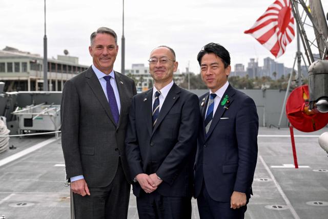 Australia's Deputy Prime Minister and Minister for Defence Richard Marles (L) and Japan's Minister of Defense Koizumi Shinjiro (R) pose for a photo with Eisaku Ito, Pesident and CEO of Mitsubishi Heavy Industries, before the signing of the contract for Japan to deliver the first three of Mogami-class warships, in Melbourne on April 18, 2026. Japan agreed on April 18 on a deal to provide Australia's navy with the first of almost a dozen stealth frigates, part of a wider military build up by Canberra aimed at boosting its long-range firepower to deter China. (Photo by William WEST / AFP)