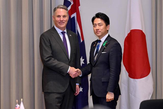 Australia's Deputy Prime Minister and Minister for Defence Richard Marles (L) and Japan's Minister of Defense Koizumi Shinjiro shake hands during a Defence Ministers' Meeting at the Commonwealth Parliament Offices in Melbourne on April 18, 2026. Japan agreed on April 18 on a deal to provide Australia's navy with the first of almost a dozen stealth frigates, part of a wider military build up by Canberra aimed at boosting its long-range firepower to deter China. (Photo by William WEST / AFP)