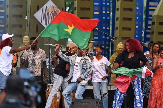 People dance with the Burkina Faso flag at the 14th edition of the African Entertainment Arts Market (MASA) at the palais de la Culture in Abidjan on April 17, 2026. (Photo by Issouf SANOGO / AFP)