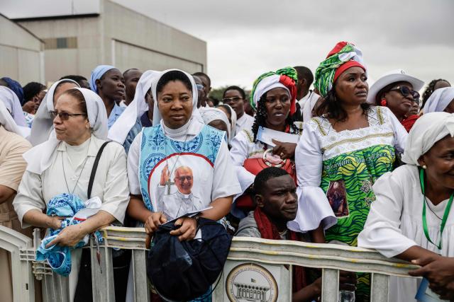 Faithfuls gather ahead of the arrival of Pope Leo XIV to lead the Holy Mass at the Yaounde Ville Airport in Yaounde on the sixth day of an 11-day apostolic journey to Africa, on April 18, 2026. (Photo by Patrick MEINHARDT / AFP)