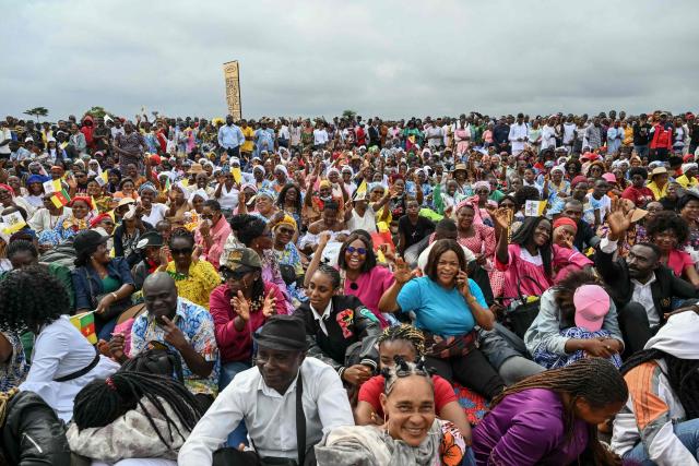 Faithfuls gather ahead of the arrival of Pope Leo XIV to lead a Holy Mass at the Yaounde Ville Airport in Yaounde on the sixth day of an 11-day apostolic journey to Africa, on April 18, 2026. (Photo by Alberto PIZZOLI / AFP)