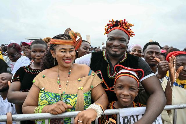 Faithfuls gather ahead of the arrival of Pope Leo XIV to lead a Holy Mass at the Yaounde Ville Airport in Yaounde on the sixth day of an 11-day apostolic journey to Africa, on April 18, 2026. (Photo by Alberto PIZZOLI / AFP)