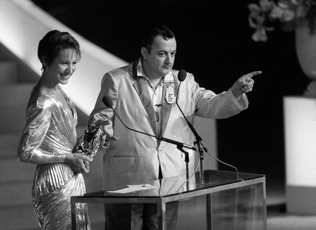 (FILES) French comedian Coluche (R) and actress Nathalie Baye present the César for Best Actor to Alain Delon for his performance in the film "Notre histoire" by Bertrand Blier at the Théâtre de l'Empire in Paris on March 3, 1985. Nathalie Baye, 77, passed away on April 17, 2026, announced her family to Agence France-Presse on April 18, 2026. (Photo by PIERRE VERDY and JEAN-LOUP GAUTREAU / AFP)