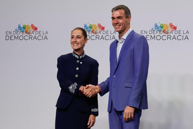 Mexico's President Claudia Sheinbaum (L) greets Spain's Prime Minister Pedro Sanchez at a "Meeting in Defence of Democracy", a meeting of leftist leaders seeking to rally against the threat to democracy from the far right in Barcelona on April 18, 2026. The gathering comes as democratic institutions and values have faced growing threats around the globe from advancing authoritarian and far-right forces in the age of US President Donald Trump. Many of the participants will take part in the first edition of the so-called "Global Progressive Mobilisation" which will be held in the same venue. (Photo by Oscar DEL POZO / AFP)