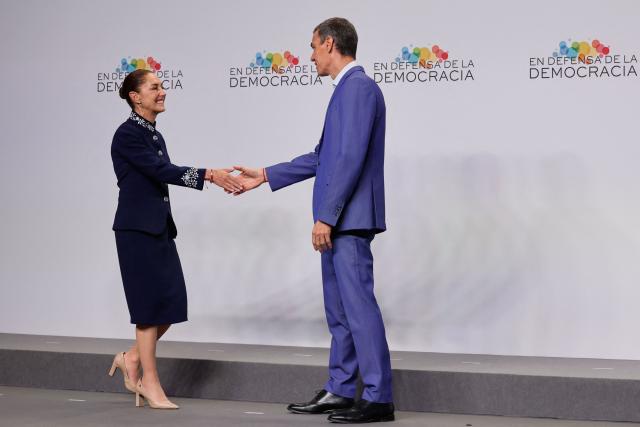 Mexico's President Claudia Sheinbaum (L) greets Spain's Prime Minister Pedro Sanchez at a "Meeting in Defence of Democracy", a meeting of leftist leaders seeking to rally against the threat to democracy from the far right in Barcelona on April 18, 2026. The gathering comes as democratic institutions and values have faced growing threats around the globe from advancing authoritarian and far-right forces in the age of US President Donald Trump. Many of the participants will take part in the first edition of the so-called "Global Progressive Mobilisation" which will be held in the same venue. (Photo by Oscar DEL POZO / AFP)