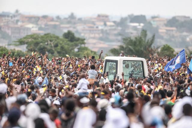 TOPSHOT - Pope Leo XIV (C) waves from the Popemobile to the crowd as he arrives to lead a Holy Mass at the Yaounde Ville Airport in Yaounde on the sixth day of an 11-day apostolic journey to Africa, on April 18, 2026. (Photo by Daniel Beloumou Olomo / AFP)