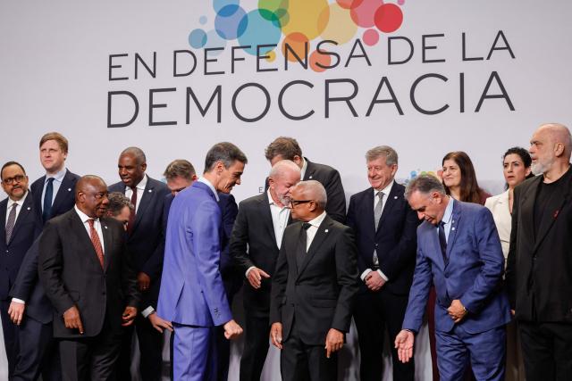 South Africa's President Cyril Ramaphosa (3L),  Spain's Prime Minister Pedro Sanchez (C), Uruguay's President Yamandu Orsi (2R front) and other attendees look for their position before a family photoat a "Meeting in Defence of Democracy", a meeting of leftist leaders seeking to rally against the threat to democracy from the far right in Barcelona on April 18, 2026. The gathering comes as democratic institutions and values have faced growing threats around the globe from advancing authoritarian and far-right forces in the age of US President Donald Trump. Many of the participants will take part in the first edition of the so-called "Global Progressive Mobilisation" which will be held in the same venue. (Photo by Oscar DEL POZO / AFP)