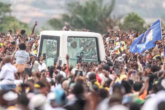 Pope Leo XIV (C) waves from the Popemobile to the crowd as he arrives to lead a Holy Mass at the Yaounde Ville Airport in Yaounde on the sixth day of an 11-day apostolic journey to Africa, on April 18, 2026. (Photo by Daniel Beloumou Olomo / AFP)