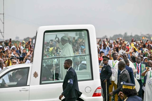 Pope Leo XIV (C) waves from the Popemobile to the crowd as he arrives to lead a Holy Mass at the Yaounde Ville Airport in Yaounde on the sixth day of an 11-day apostolic journey to Africa, on April 18, 2026. (Photo by Alberto PIZZOLI / AFP)