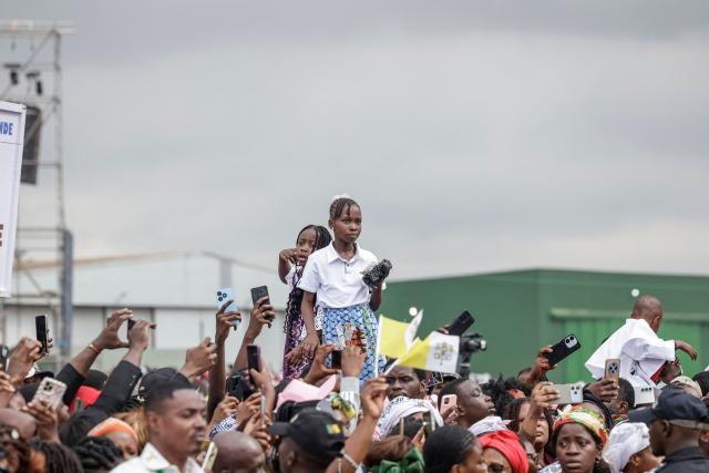 A young faithful watches as Pope Leo XIV (unseen) arrives in the Popemobile to lead a Holy Mass at the Yaounde Ville Airport in Yaounde on the sixth day of an 11-day apostolic journey to Africa, on April 18, 2026. (Photo by Patrick MEINHARDT / AFP)