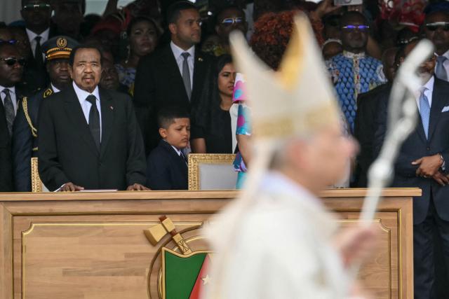 Cameroon's President Paul Biya (L) watches as Pope Leo XIV (front) arrives to lead a Holy Mass at the Yaounde Ville Airport in Yaounde on the sixth day of an 11-day apostolic journey to Africa, on April 18, 2026. (Photo by Alberto PIZZOLI / AFP)