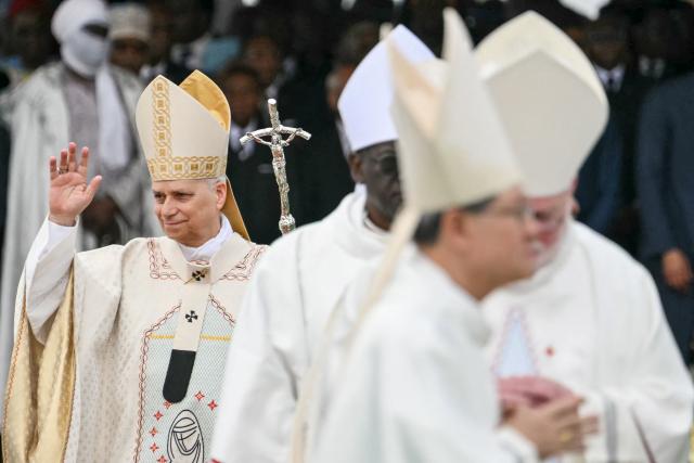 Pope Leo XIV (L) waves as he arrives to lead a Holy Mass at the Yaounde Ville Airport in Yaounde on the sixth day of an 11-day apostolic journey to Africa, on April 18, 2026. (Photo by Alberto PIZZOLI / AFP)