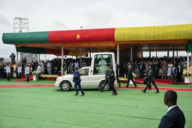 Pope Leo XIV (C) arrives in the Popemobile to lead a Holy Mass at the Yaounde Ville Airport in Yaounde on the sixth day of an 11-day apostolic journey to Africa, on April 18, 2026. (Photo by Alberto PIZZOLI / AFP)