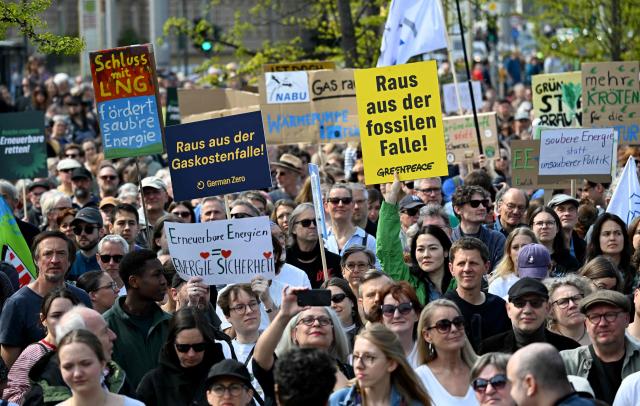 Activists and supporters of Fridays for Future, Campact and other groups hold up placards as they demonstrate against the German government's energy policy, on April 18, 2026 in Berlin. Activists call for faster expansion of solar and wind energy, rapid development of distribution grids, storage and digitalization, a strong European clean energy industry, lower electricity taxes and cheaper power for heat pumps, as well as social support and tenant protection to ensure affordable, climate-friendly heating. (Photo by RALF HIRSCHBERGER / AFP)