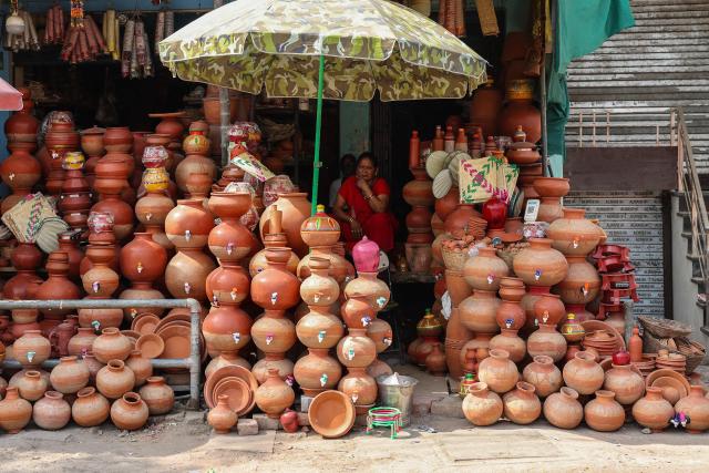 A vendor selling earthen water pots sits under a shelter as she waits for customers along a street on a hot summer day in Varanasi on April 18, 2026. (Photo by Niharika KULKARNI / AFP)