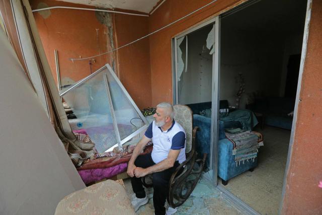 A resident sits inside his damaged house upon his return to a neighborhood in Beirut’s southern suburbs, on April 18, 2026. Lebanese President Joseph Aoun said on April 17 that his country was on the verge of a "new phase" of "permanent agreements", after the 10-day ceasefire in the Israel-Hezbollah war went into force. Lebanon was drawn into the Middle East conflict on March 2 when Tehran-backed Hezbollah attacked Israel to avenge the death of Iranian supreme leader Ali Khamenei. (Photo by Ibrahim AMRO / AFP) / 