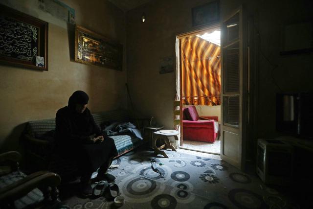 A resident sits inside her damaged house upon her return to a neighborhood in Beirut’s southern suburbs, on April 18, 2026. Lebanese President Joseph Aoun said on April 17 that his country was on the verge of a "new phase" of "permanent agreements", after the 10-day ceasefire in the Israel-Hezbollah war went into force. Lebanon was drawn into the Middle East conflict on March 2 when Tehran-backed Hezbollah attacked Israel to avenge the death of Iranian supreme leader Ali Khamenei. (Photo by Ibrahim AMRO / AFP) / 