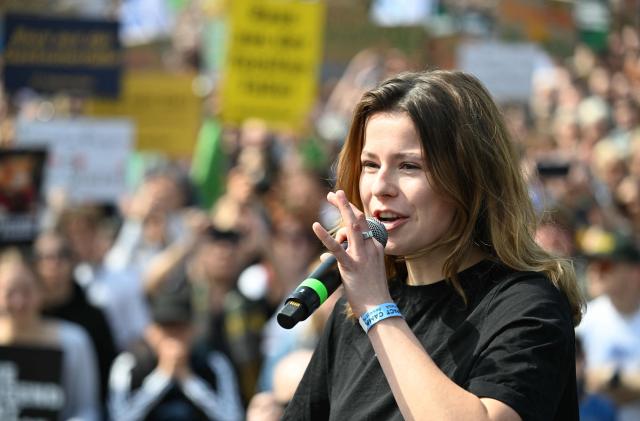 German climate activist Luisa Neubauer addresses activists and supporters of Fridays for Future, Campact and other groups as they demonstrate against the German government's energy policy, on April 18, 2026 in Berlin. Activists call for faster expansion of solar and wind energy, rapid development of distribution grids, storage and digitalization, a strong European clean energy industry, lower electricity taxes and cheaper power for heat pumps, as well as social support and tenant protection to ensure affordable, climate-friendly heating. (Photo by RALF HIRSCHBERGER / AFP)