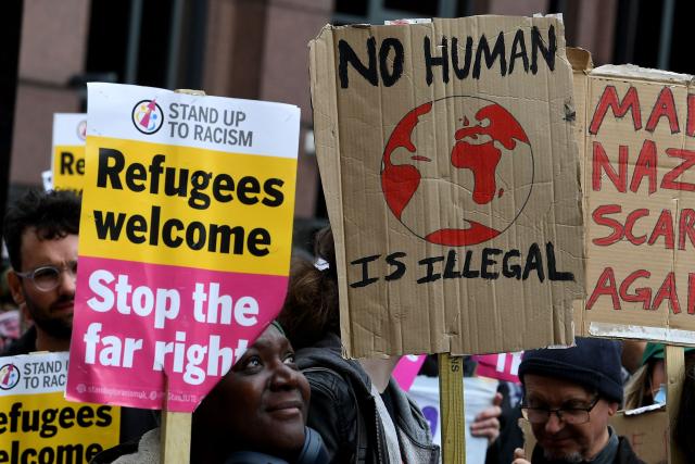 Counter protests hold placards, as a Britain First march takes place in Manchester on April, 18, 2026. (Photo by PETER POWELL / AFP)