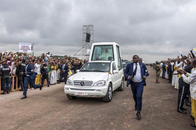 Pope Leo XIV (C) waves from the Popemobile to the crowd as he arrives to lead a Holy Mass at the Yaounde Ville Airport in Yaounde on the sixth day of an 11-day apostolic journey to Africa, on April 18, 2026. (Photo by PATRICK MEINHARDT / AFP)