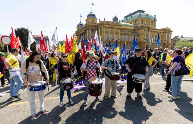 Drummers perform as protesters wave flags and placards during the demonstration "Croatia Together for Higher Wages and Pensions" organized by trade unions and pensioners against low incomes and the highest inflation in the eurozone, in downtown Zagreb on April 18, 2026. In March, Croatia’s annual inflation rate was the 4.89 percent, the highest in the eurozone, where it reached 2.6 percent. (Photo by MARKO PERKOV / AFP)