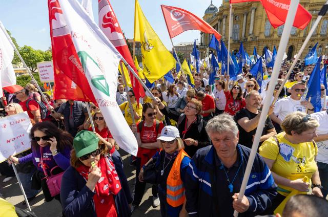Protesters wave flags and placards during the demonstration "Croatia Together for Higher Wages and Pensions" organized by trade unions and pensioners against low incomes and the highest inflation in the eurozone, in downtown Zagreb on April 18, 2026. In March, Croatia’s annual inflation rate was the 4.89 percent, the highest in the eurozone, where it reached 2.6 percent. (Photo by MARKO PERKOV / AFP)