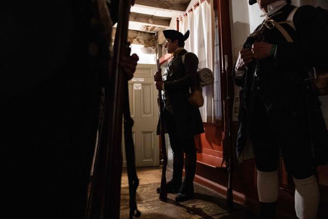 Lexington Minute Men reenactors stand near a tavern during a battle reenactment of the Battle of Lexington and Concord as part of Patriot's Day celebrations in Lexington, Massachusetts, on April 18, 2026. April 19, 2026 marks the 250th anniversary of the Battle of Lexington and Concord, the first major military actions between the British Army and the Colonial American militias during the American Revolutionary War. (Photo by Joseph Prezioso / AFP)